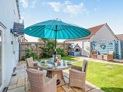 a patio with a table with a blue umbrella at 3 Bed in Newquay oc-47630 in Newquay
