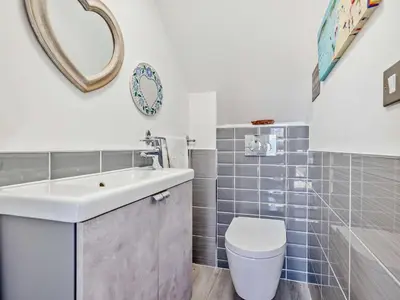 a bathroom with a sink and a toilet and a mirror at 3 Bed in Newquay oc-47630 in Newquay