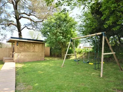 a playground with a swing in a yard at 4 Bed in Callington oc-54343 in Linkinhorne