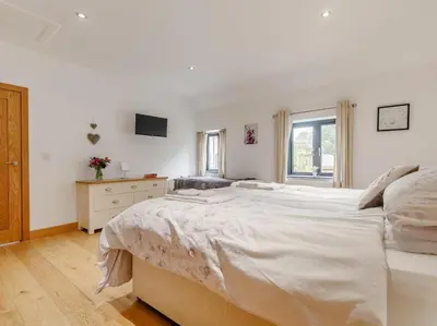 a white bedroom with a large bed and a window at 1 Bed in Callington oc-54344 in Linkinhorne