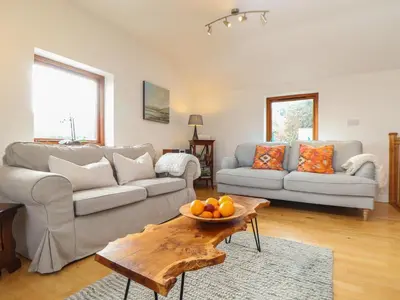 a living room with a couch and a table at Little Fernleigh in Helston