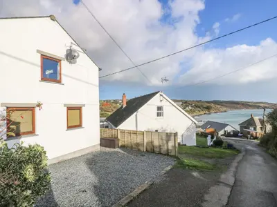 a white house with a view of the water at Little Fernleigh in Helston