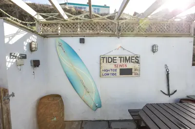 a wall with a surfboard and a sign on it at UPPER BEACH HOUSE in Portreath