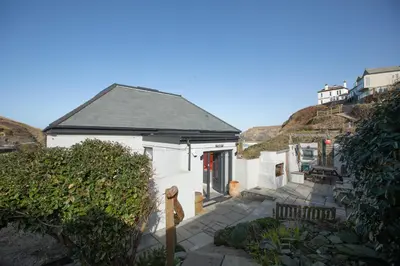 a small white house with a pathway leading to it at UPPER BEACH HOUSE in Portreath