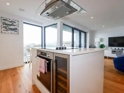 a kitchen with an island with a stove top oven at Towan Penthouse in Newquay