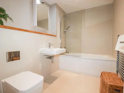 a bathroom with a toilet and a sink and a bath tub at Towan Penthouse in Newquay