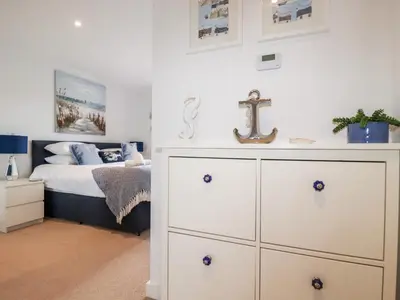 a bedroom with a white dresser and a bed at Towan Penthouse in Newquay