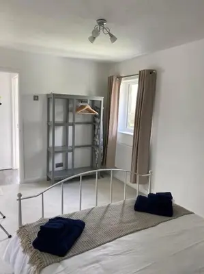 a bedroom with a bed with two blue pillows on it at The Artists Barn in Launceston