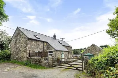 an old stone cottage with a wooden gate at The Artists Barn in Launceston