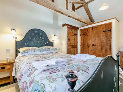 a bedroom with a large bed with a floral bedspread at 2 Bed in Launceston oc-02043 in North Petherwin