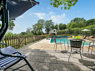 a pool with chairs and a table next to a fence at 2 Bed in Launceston oc-02043 in North Petherwin