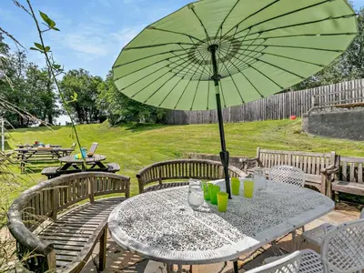 a table with a green umbrella on a patio at 2 Bed in Launceston oc-02038 in North Petherwin