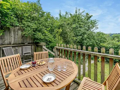 a wooden table and chairs on a wooden deck at 2 Bed in Launceston oc-02033 in North Petherwin