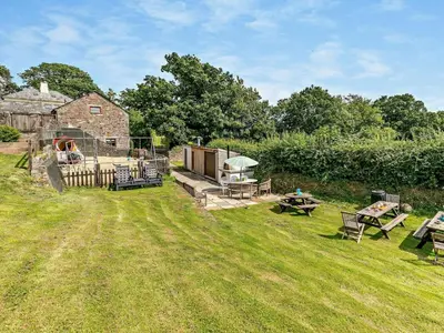 a yard with a stone house with a picnic table at 2 Bed in Launceston oc-02033 in North Petherwin