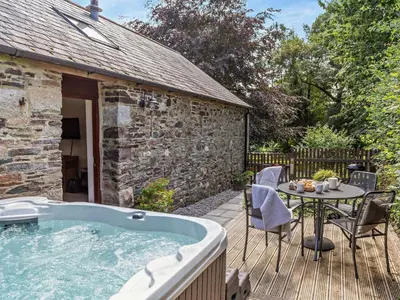 a hot tub on a deck with a table and chairs at 2 Bed in Callington oc-tyler in North Hill