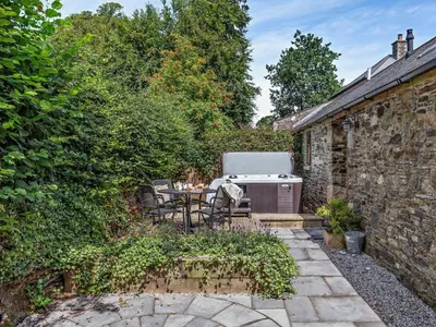 a patio with a table and a barbecue in a garden at 2 Bed in Callington oc-tyler in North Hill