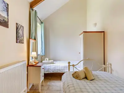 a bedroom with two beds and a dresser and a mirror at 2 Bed in Callington oc-tyler in North Hill