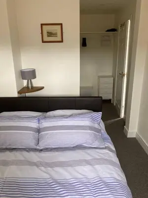 a bedroom with a bed with a blue and white stripes at Praa Sands - Apartment - Sleeps 2 - Parking in Praa Sands