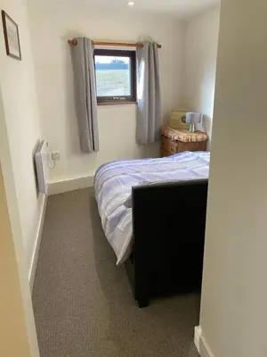 a small bedroom with a bed and a window at Praa Sands - Apartment - Sleeps 2 - Parking in Praa Sands