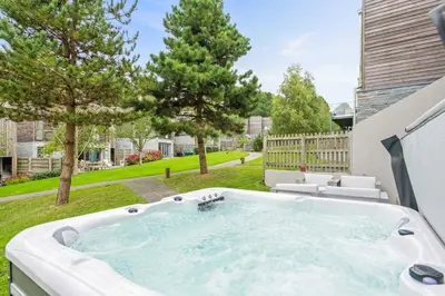 a hot tub in the backyard of a house at House 12 in Looe
