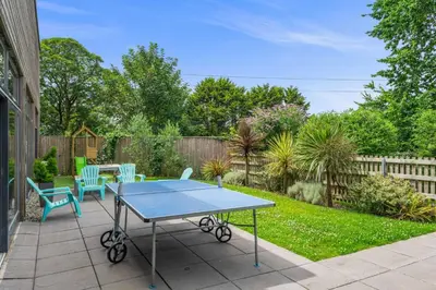 a ping pong table and chairs on a patio at House 12 in Looe