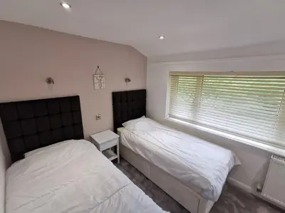 a bedroom with two beds and a window at Cornwall Holiday Home, Casa Da Praia in Saint Columb Major