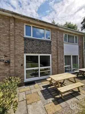 a wooden picnic table in front of a brick building at Cornwall Holiday Home, Casa Da Praia in Saint Columb Major