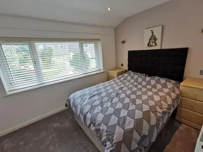 a bedroom with a bed and a large window at Cornwall Holiday Home, Casa Da Praia in Saint Columb Major