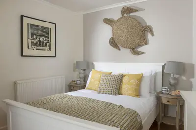 a bedroom with a bed with a stuffed animal on the wall at Tathra Beach Cottage in St Ives