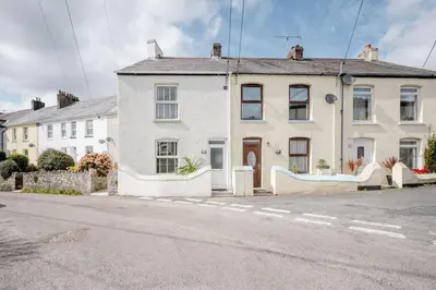 a white house on the side of a street at Cosy cottage near the coast in Tywardreath