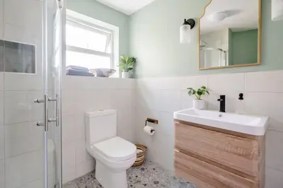 a bathroom with a toilet and a sink and a mirror at Cosy cottage near the coast in Tywardreath