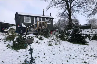 a house in a yard with snow on the ground at 1 Bedroom Cabin Sleeps 2 Private Garden WiFi in Camelford