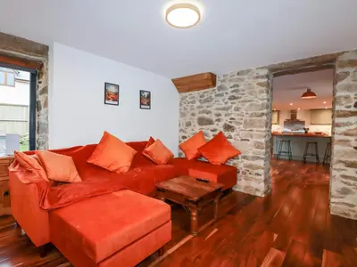 a living room with a red couch and a table at The Old Cattle Barn in Launceston
