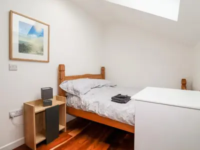a small bedroom with a bed and a tv at The Old Cattle Barn in Launceston