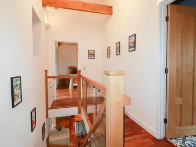 a stairwell in a home with white walls and wooden floors at The Old Cattle Barn in Launceston