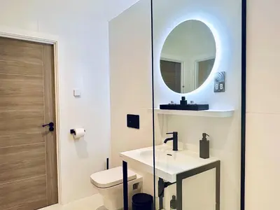 a bathroom with a toilet and a sink and a mirror at Quiet Clifftop luxury apartment with partial seaviews in Newquay