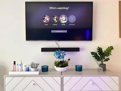 a tv on a wall in a living room with plants at Quiet Clifftop luxury apartment with partial seaviews in Newquay