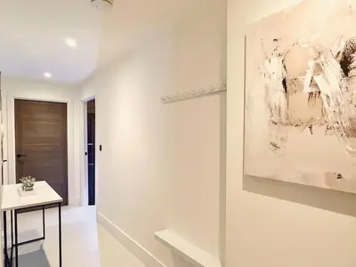 a white room with a table and a painting on the wall at Quiet Clifftop luxury apartment with partial seaviews in Newquay