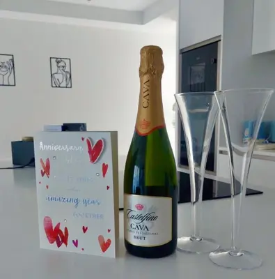 a bottle of champagne next to two glasses on a counter at Quiet Clifftop luxury apartment with partial seaviews in Newquay