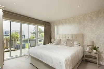 a bedroom with a large bed and a large window at Rockpool at Salt in St Ives