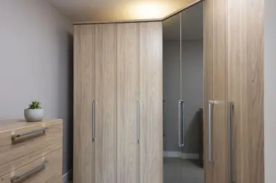 a bathroom with wooden cabinets and a shower stall at Rockpool at Salt in St Ives