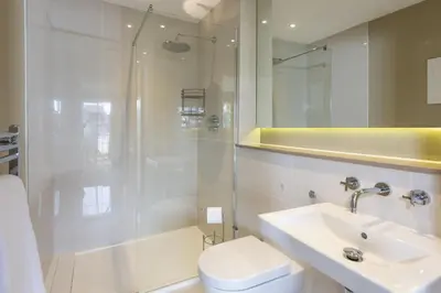a bathroom with a shower and a toilet and a sink at Rockpool at Salt in St Ives