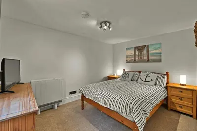 a bedroom with a bed and a tv in it at Finest Retreats - Porthole Cottage in Mevagissey