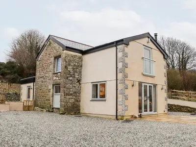 a detached stone house with a gravel driveway at La Petit Maison in Saint Columb Major