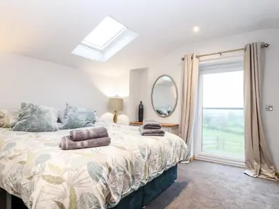 a bedroom with a bed and a window at La Petit Maison in Saint Columb Major
