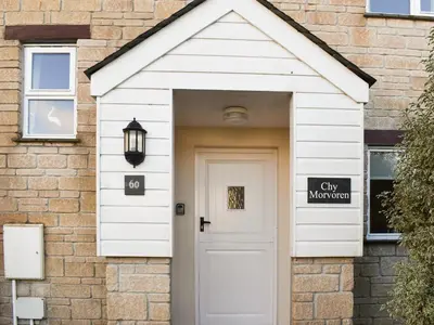 a white door in a brick house with a sign on it at Chy Morvoren in Falmouth