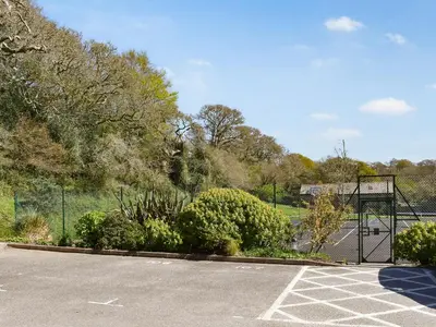 a parking lot with a basketball hoop and some bushes at Chy Morvoren in Falmouth