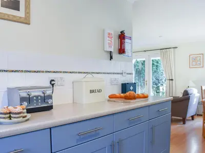 a kitchen with blue cabinets and oranges on a counter at Chy Morvoren in Falmouth