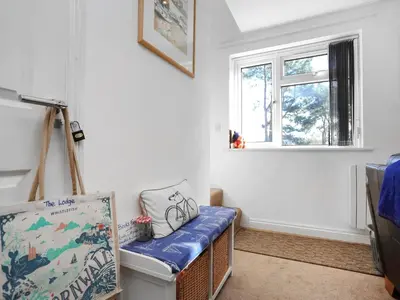 a room with a crib and a window at The Lodge in Carlyon Bay