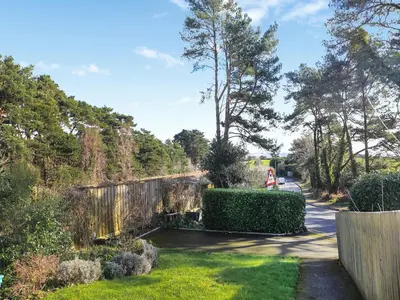 a garden with a fence and trees and grass at The Lodge in Carlyon Bay